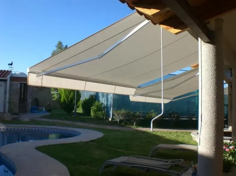 Un gran toldo blanco está sobre una piscina.