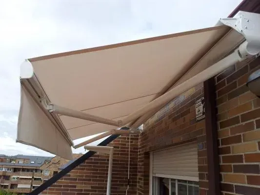 Un toldo blanco cuelga del costado de un edificio de ladrillos.