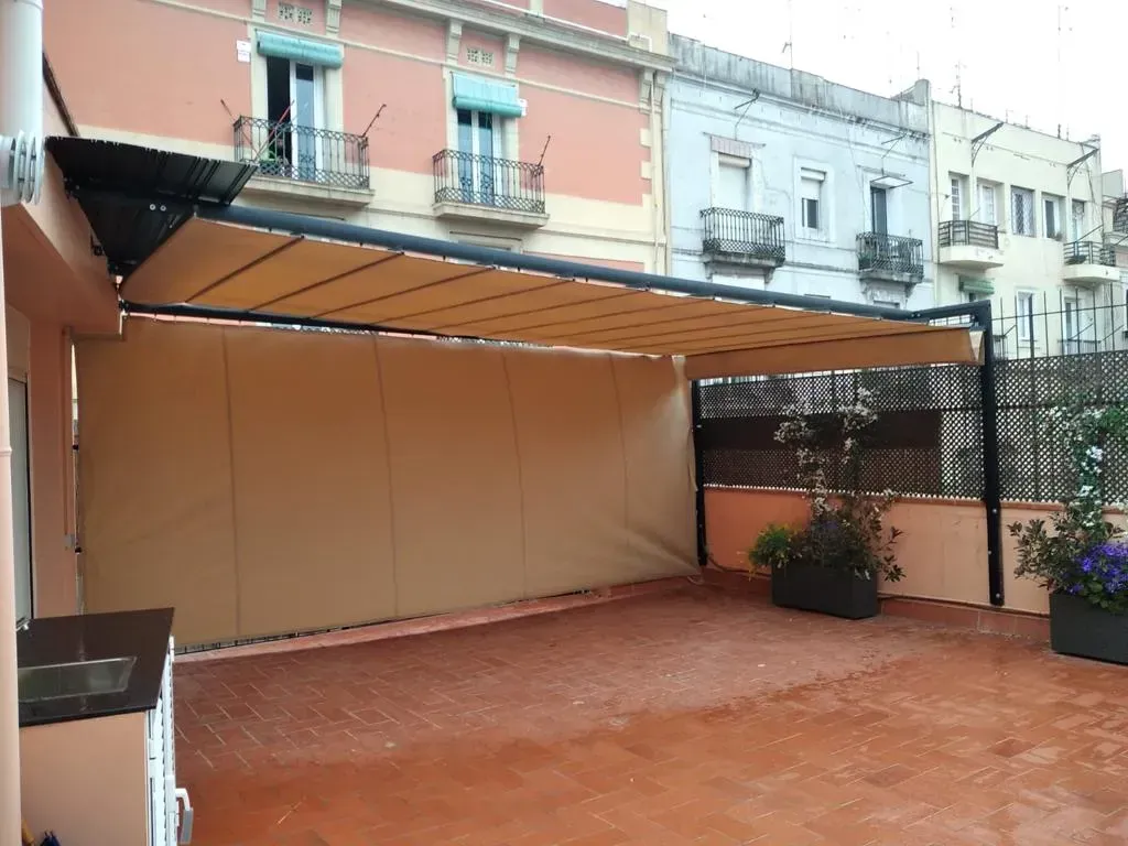 Un patio con dosel y jardinera frente a un edificio.