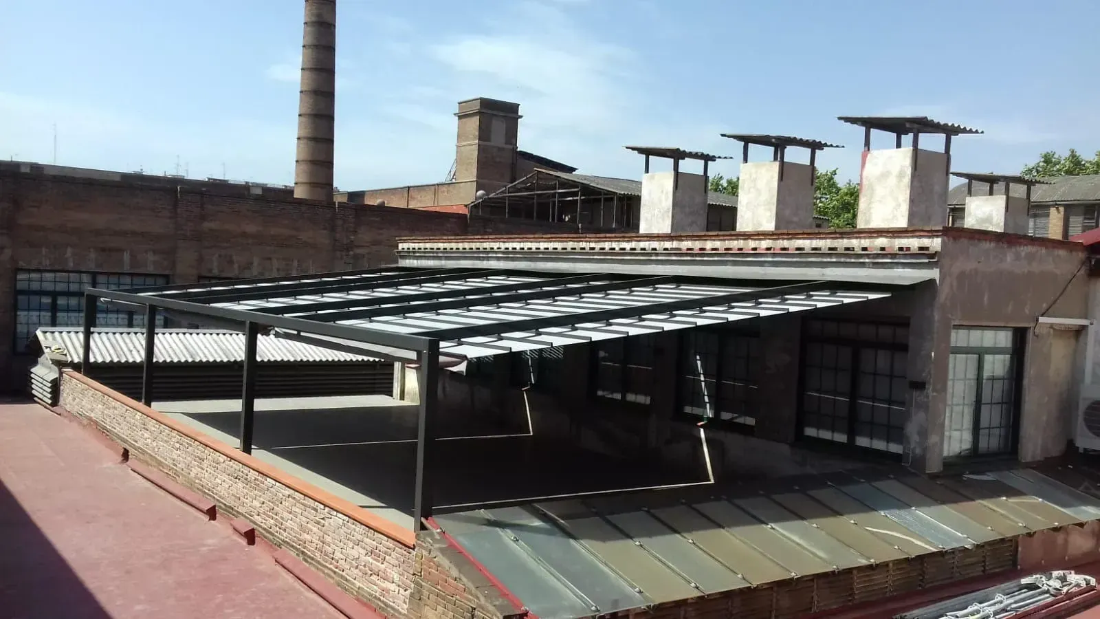 Una azotea con un dosel y chimeneas al fondo