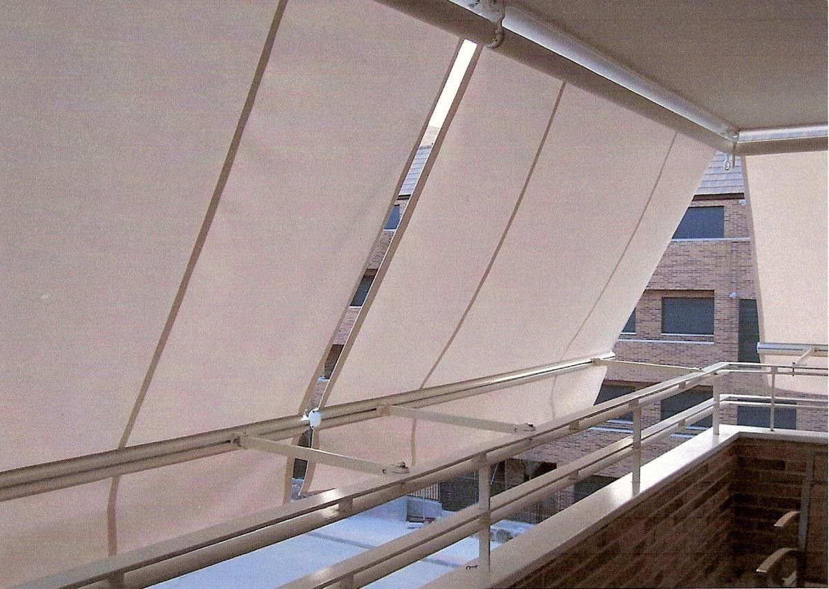 Un balcón con un toldo blanco encima.
