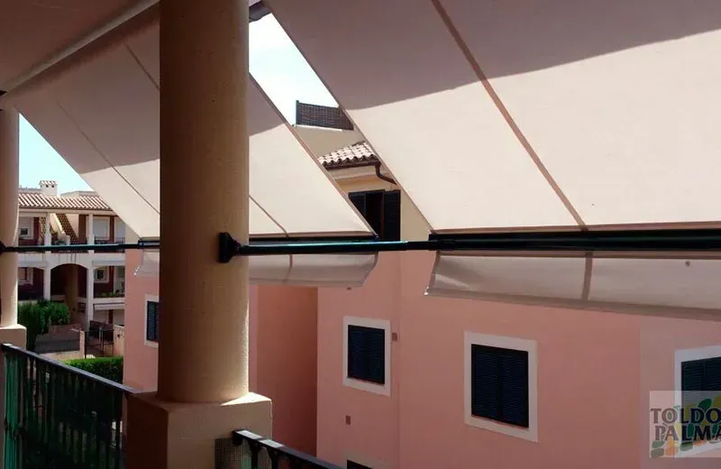 Un balcón con un toldo blanco que dice toldo palmera