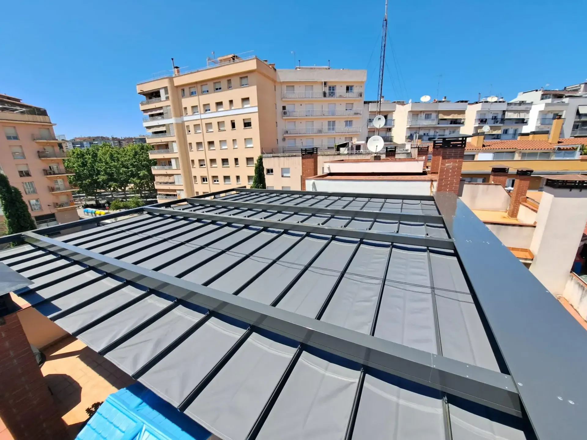 El tejado de un edificio con un toldo gris encima.