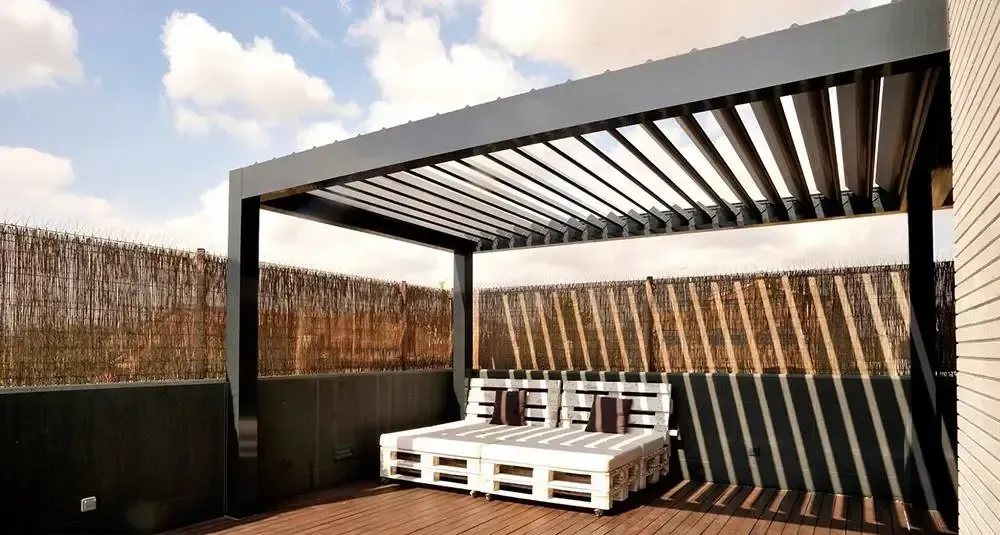 Un patio con una pérgola y un sofá debajo.