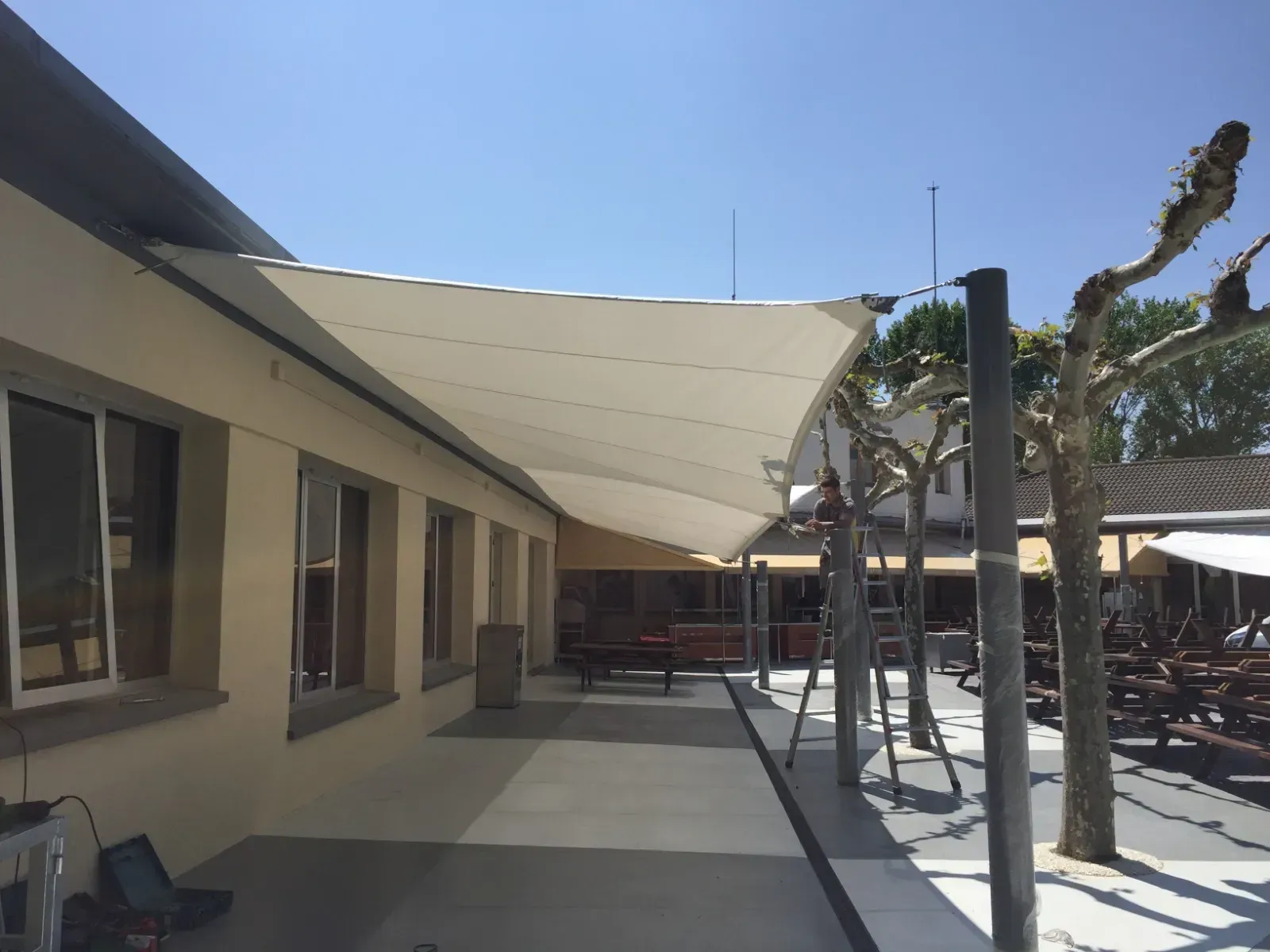 Un gran paraguas blanco cuelga del costado de un edificio.