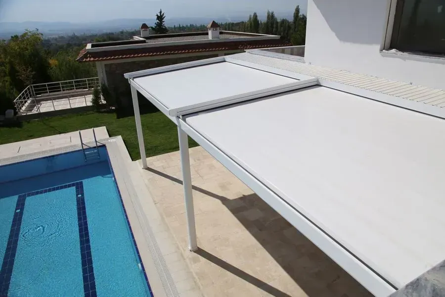 Una pérgola blanca está situada junto a una piscina.