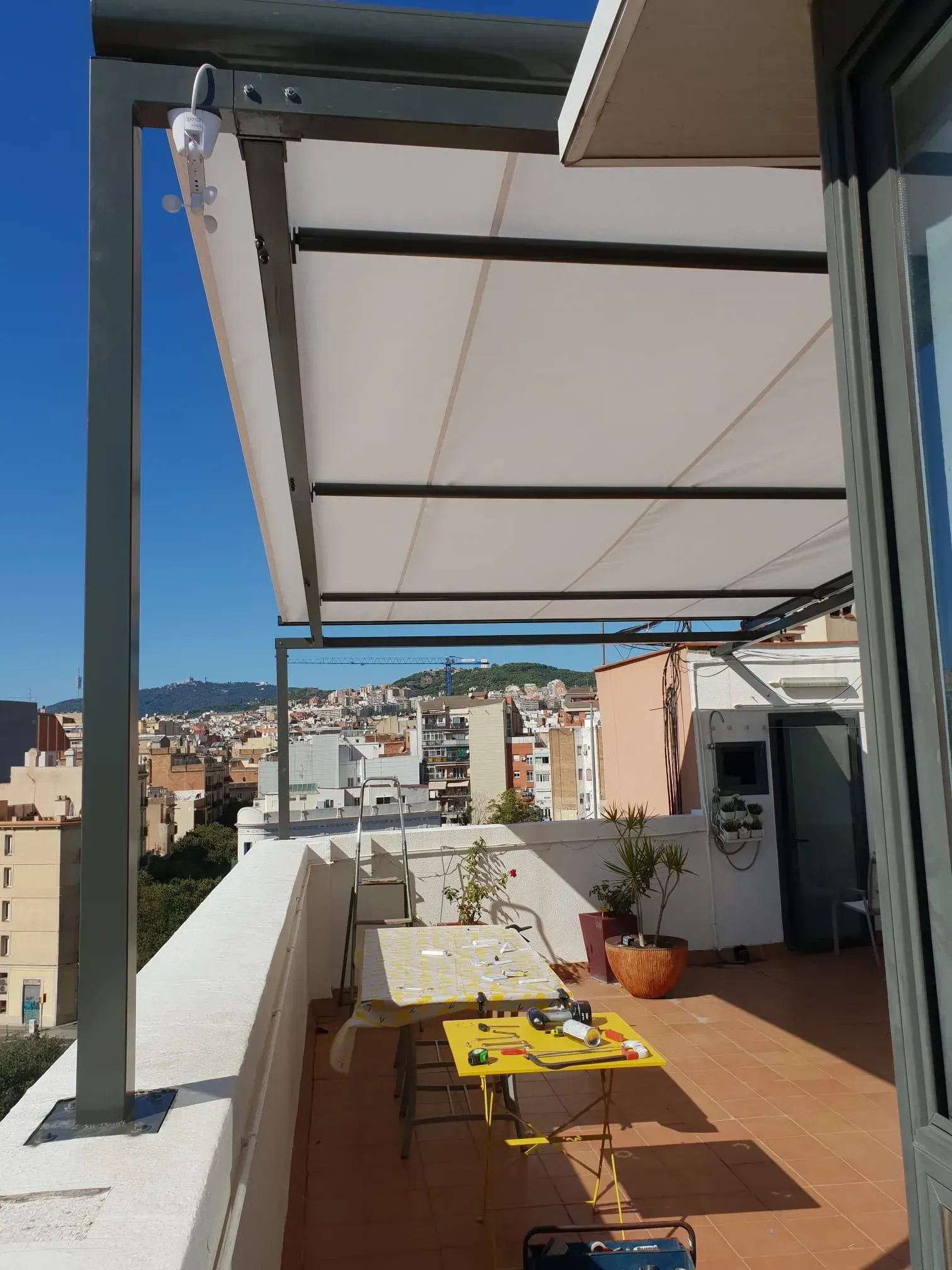 Una azotea con una mesa y sillas bajo un dosel.