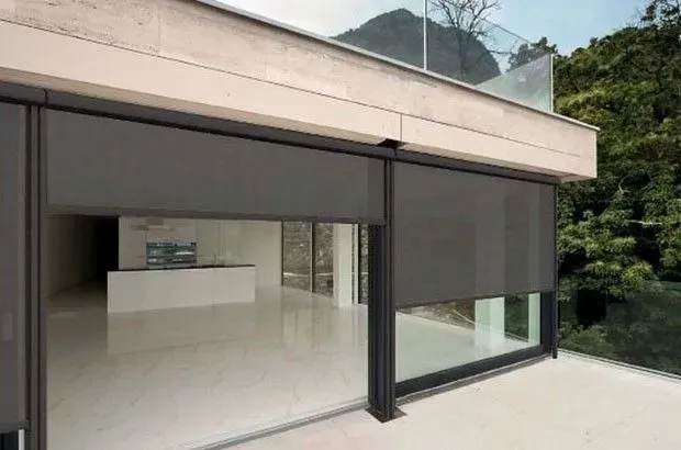 Una casa moderna con una gran puerta corrediza de vidrio y un balcón.
