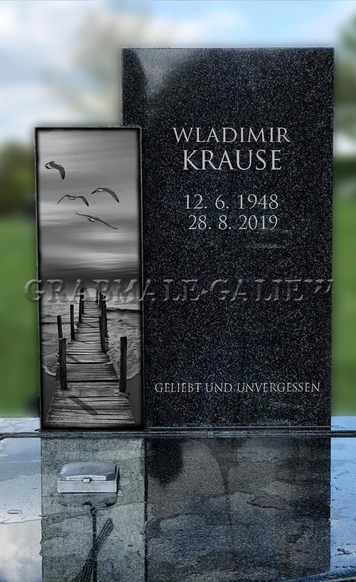 Ein Grabstein mit der Abbildung eines Docks und Vögeln darauf.