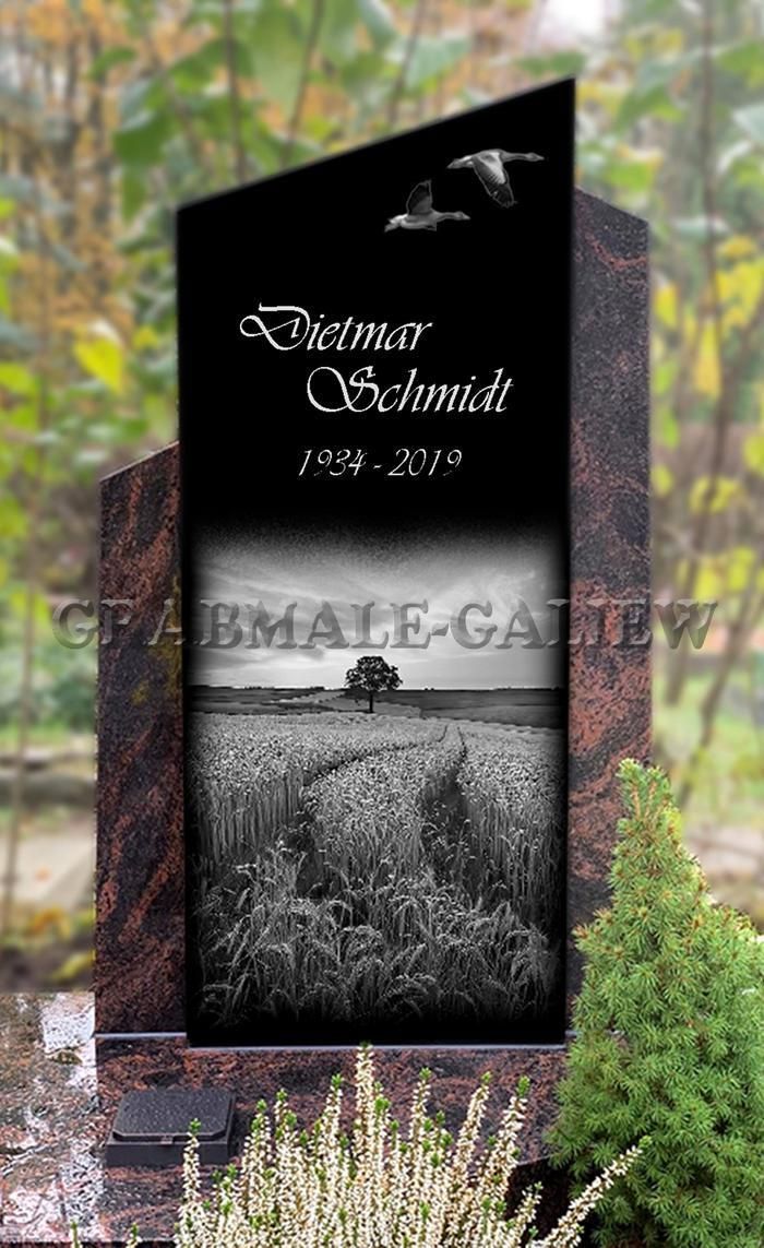 Ein schwarz-weißer Grabstein mit einem Baum und einem Vogel darauf.