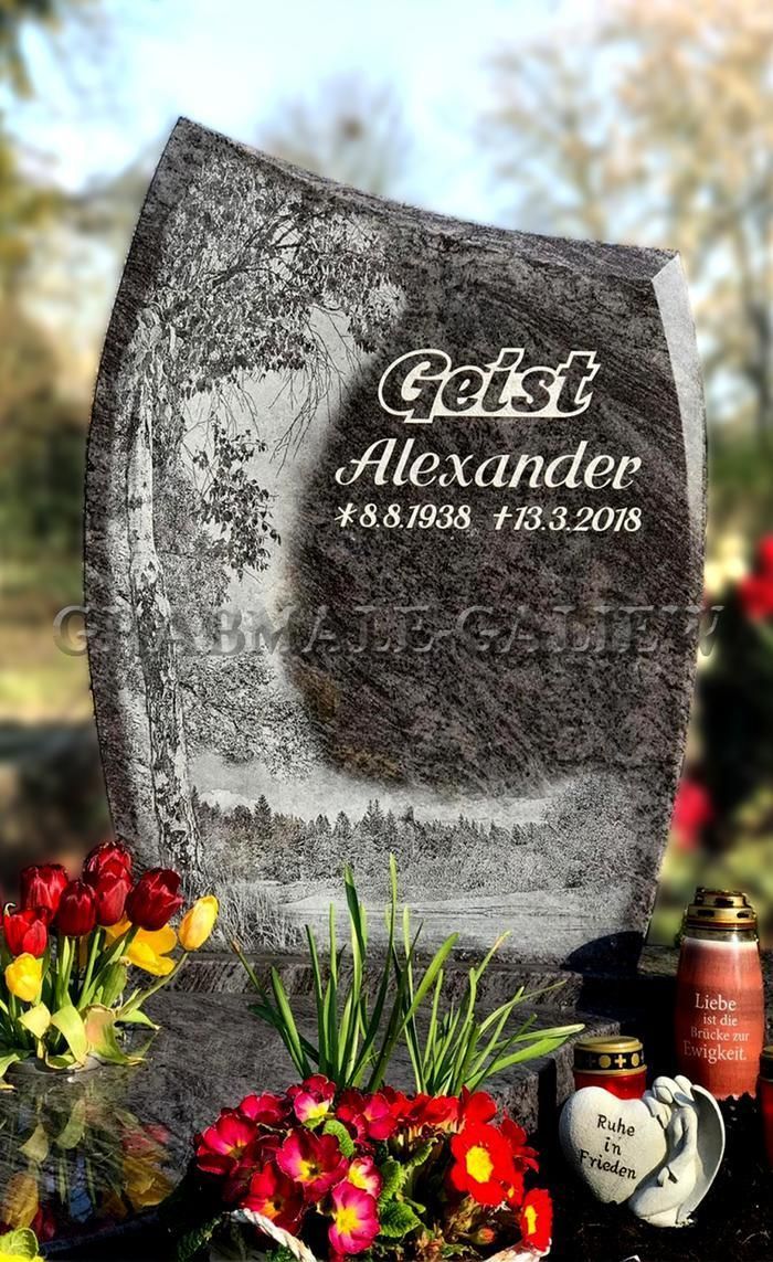 Ein Grabstein auf einem Friedhof mit Blumen und Kerzen.