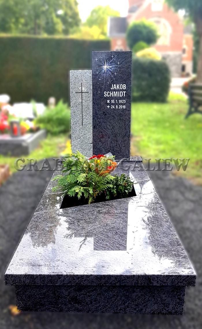 Ein Grab auf einem Friedhof mit einem Kreuz und Blumen