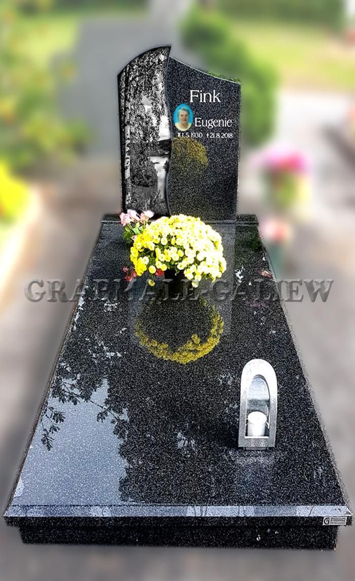 Ein Grab mit einer Blumenvase und einer Kerze darauf.