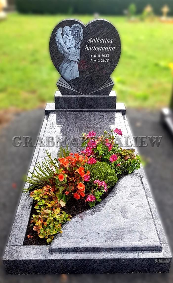 Ein Grab mit Blumen und einem herzförmigen Grabstein