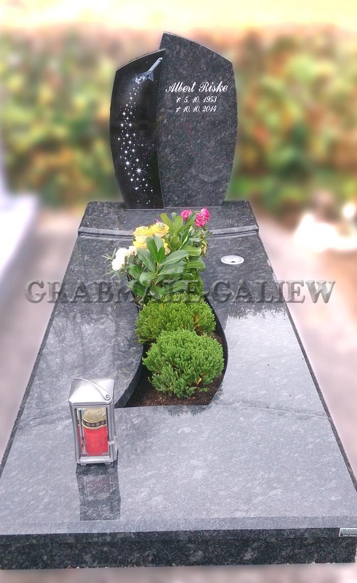 Ein Grab mit Blumen und einer Laterne darauf