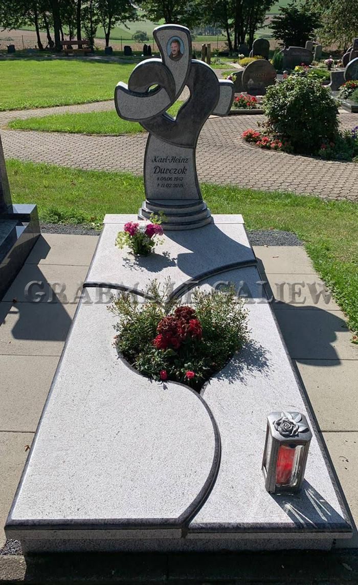 Ein Grab auf einem Friedhof mit einem Kreuz darauf