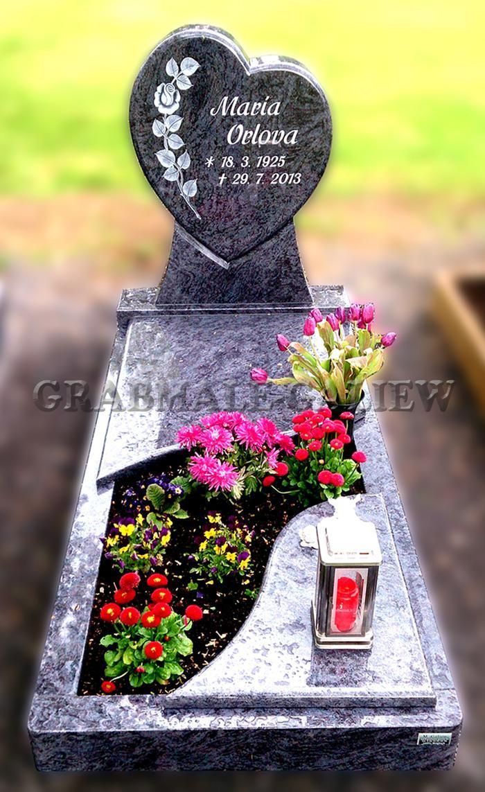 Ein herzförmiger Grabstein mit Blumen und einer Kerze darauf