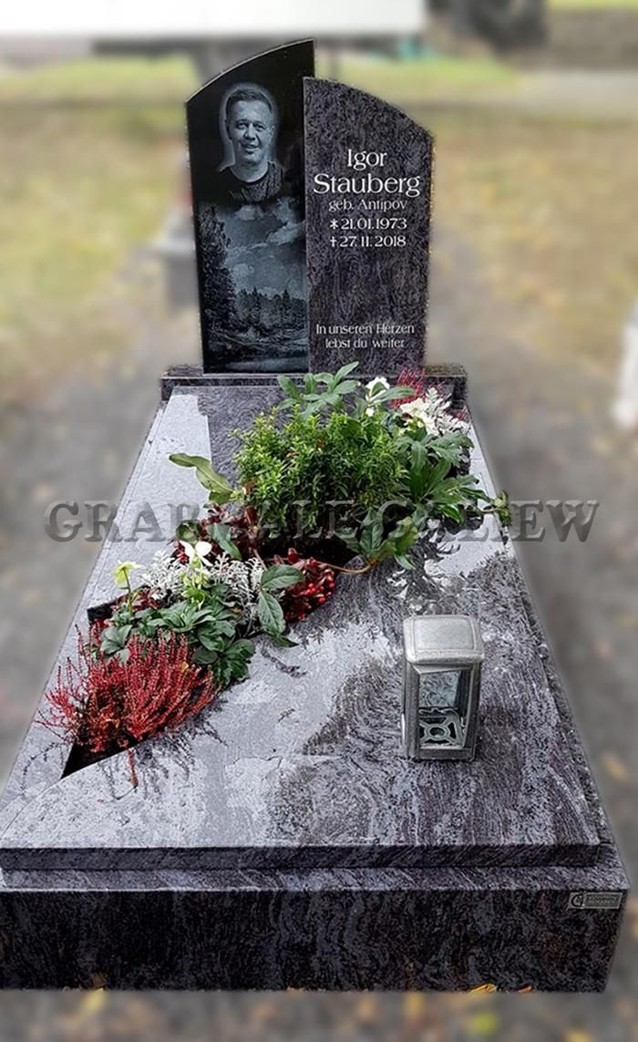 Ein Grab mit Blumen und einer Kerze darauf.