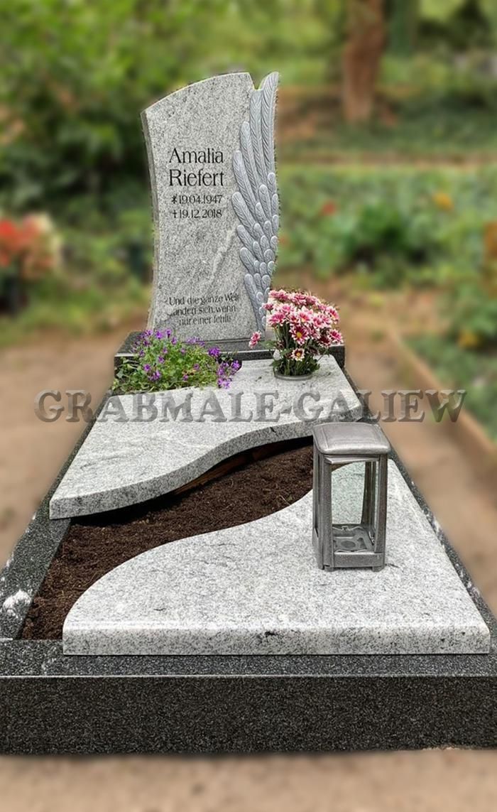 Ein Grab mit einer Laterne und Blumen darauf auf einem Friedhof.