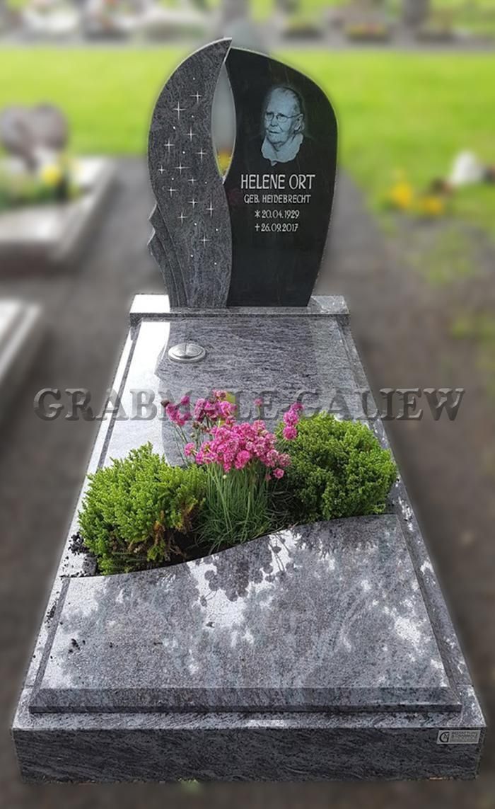 Ein Grabstein mit dem Bild eines Mannes auf einem Friedhof.