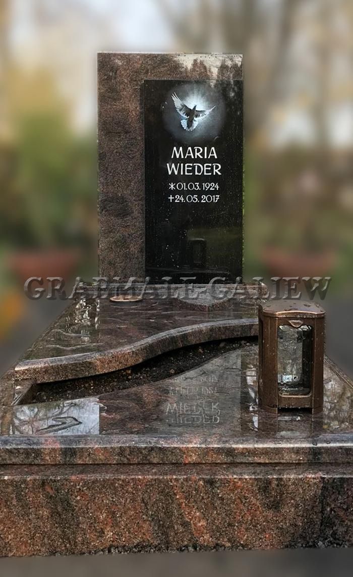 Ein Grabstein mit einer Laterne darauf auf einem Friedhof.