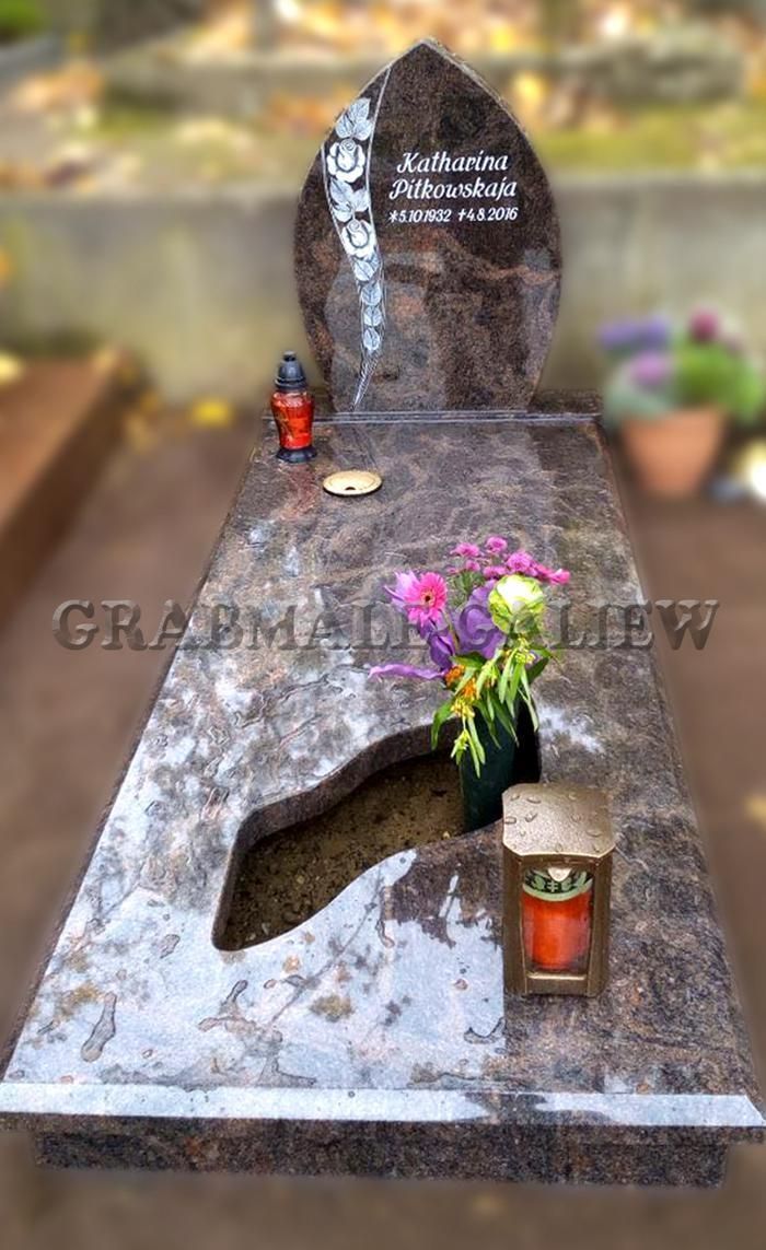 Ein Grab mit einer Blumenvase und einer Kerze darauf.