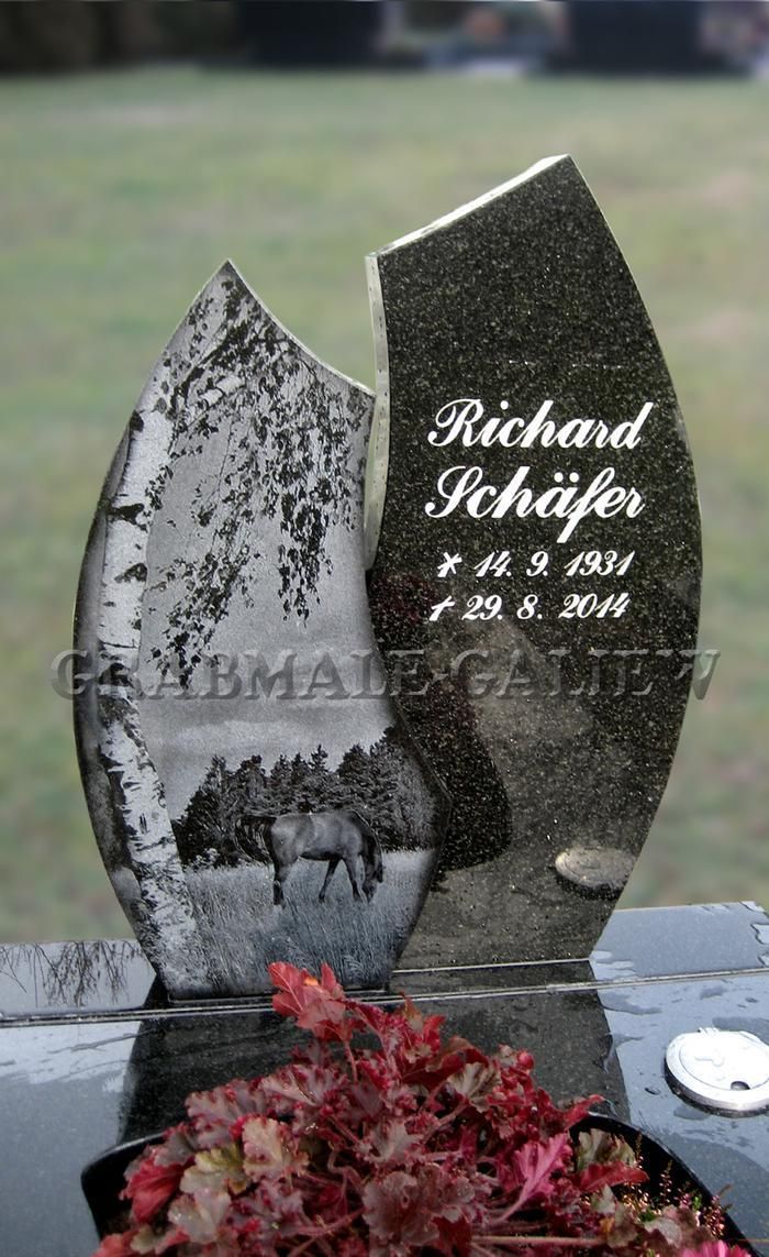 Ein Grabstein mit dem Bild eines Pferdes darauf.