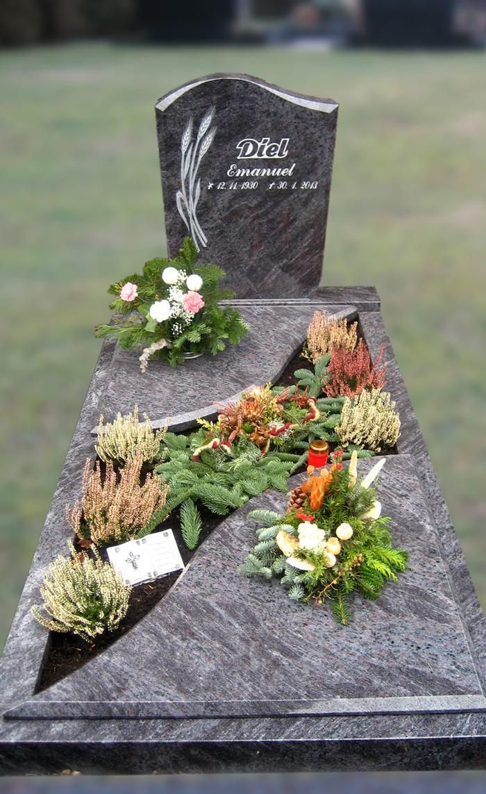 Ein Grab mit Blumen und Pflanzen auf einem Friedhof.