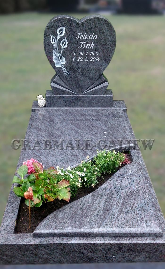 Ein Grab mit einem herzförmigen Grabstein und einem Blumentopf.