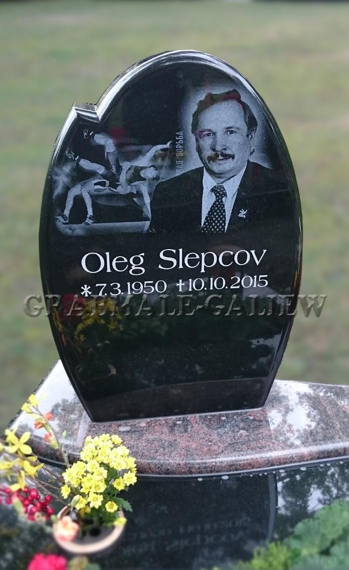 Ein schwarzer Grabstein mit dem Bild eines Mannes darauf