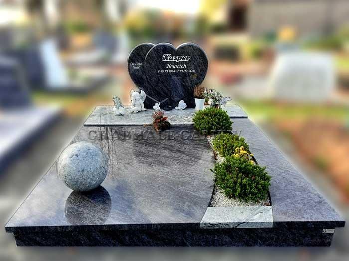 Ein Grab mit einem herzförmigen Grabstein und einer Kugel in der Mitte.