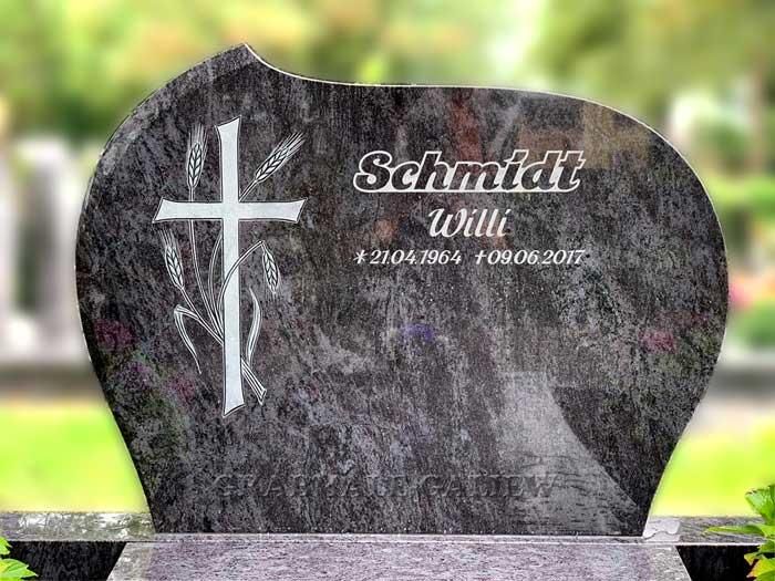 Ein Grabstein mit einem Kreuz darauf auf einem Friedhof.