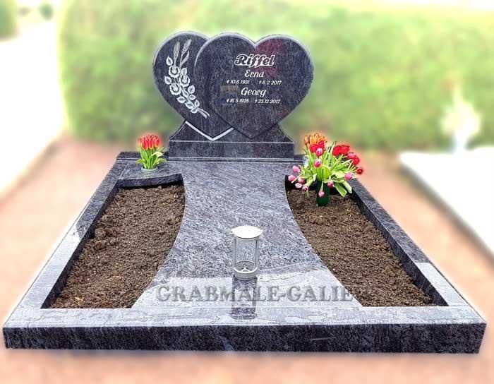 Ein Grab mit einem herzförmigen Grabstein und zwei Gräbern.