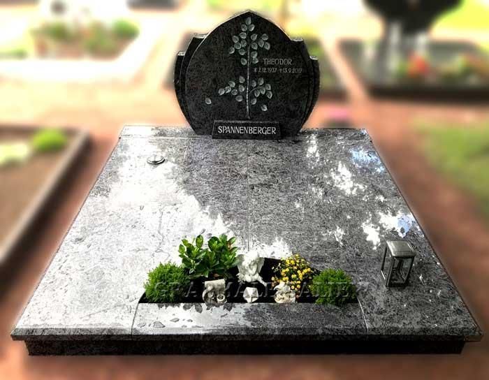 Ein Grab auf einem Friedhof mit einem Baum darauf
