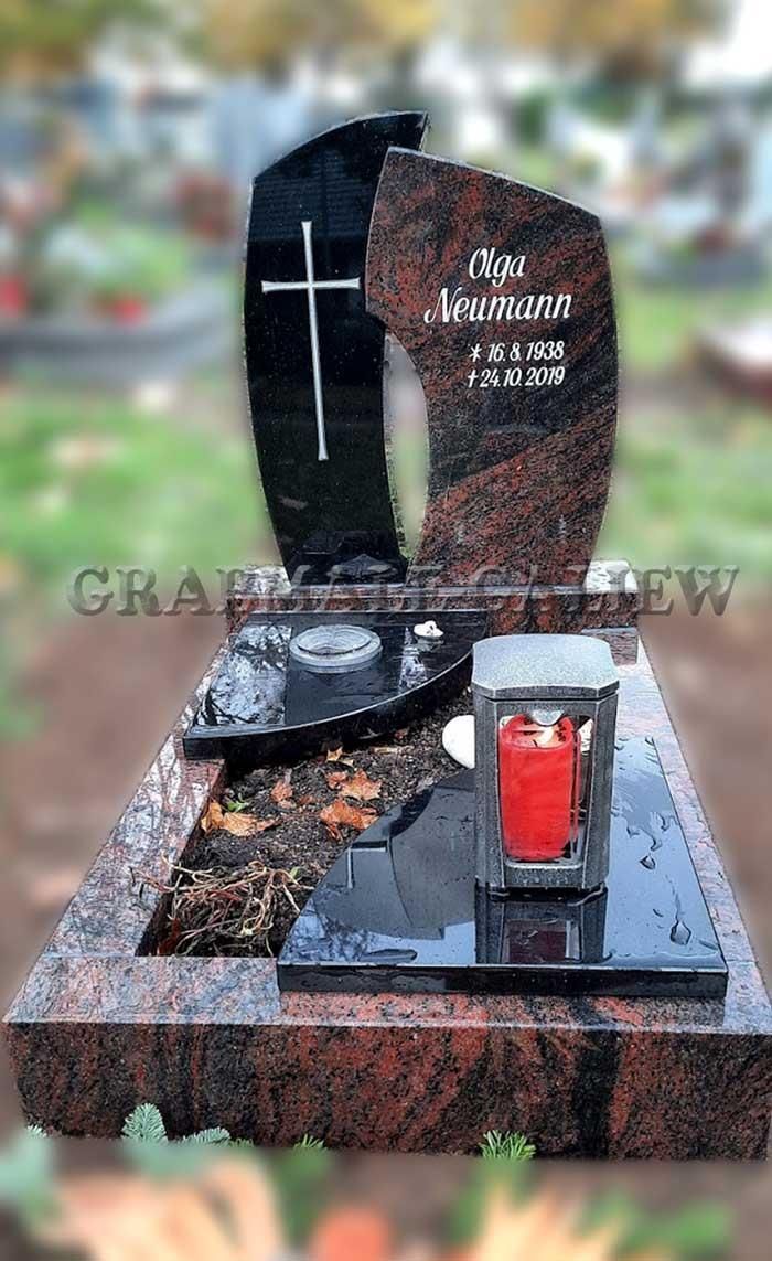 Ein Grab mit einem Kreuz und einer Kerze darauf auf einem Friedhof.