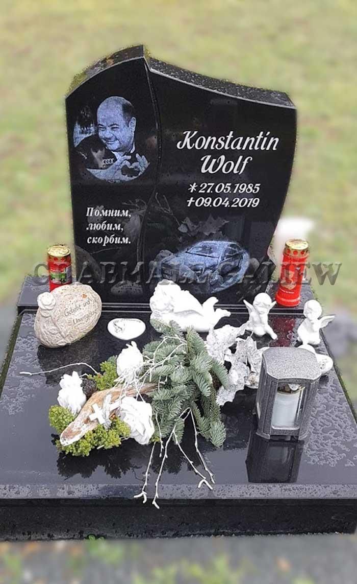 Ein schwarzer Grabstein mit dem Bild eines Babys darauf.