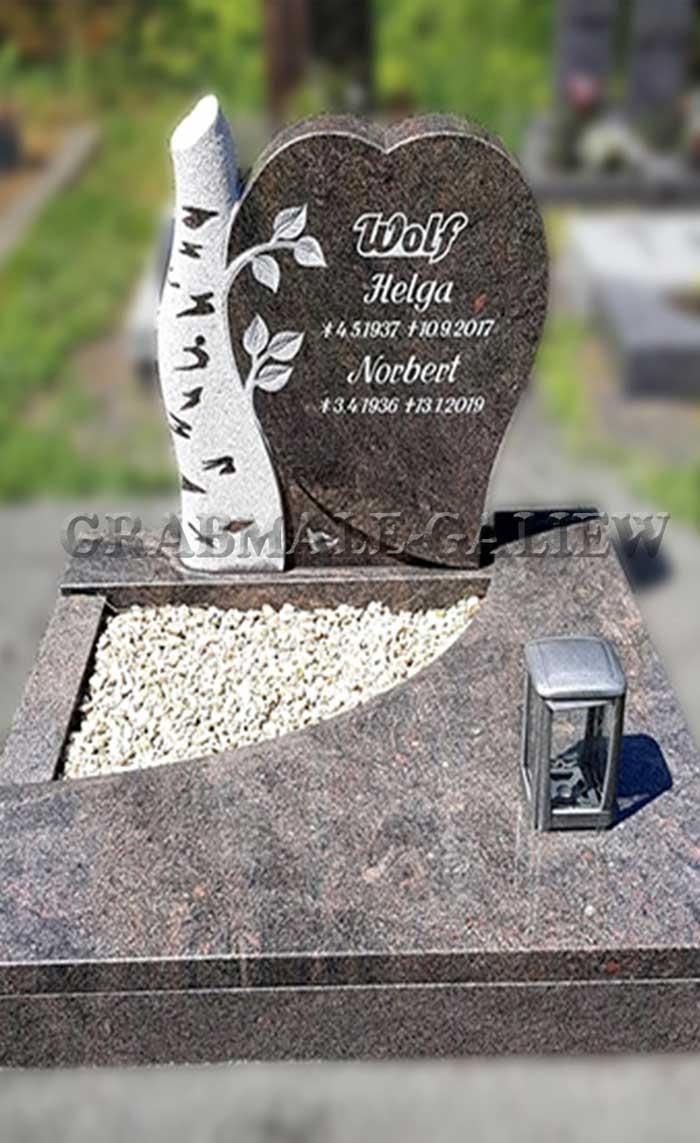 Ein Grabstein mit einem herzförmigen Grabstein und einer Laterne auf einem Friedhof.
