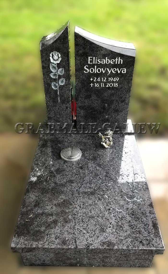 Ein schwarzer Grabstein aus Granit mit einer roten Rose darauf.