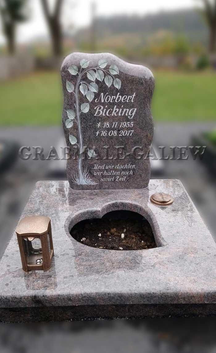 Ein Grabstein mit einem herzförmigen Loch in der Mitte.