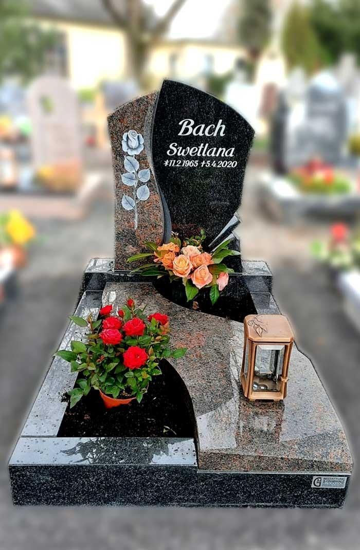 Ein Grabstein mit Blumen und einer Laterne auf einem Friedhof
