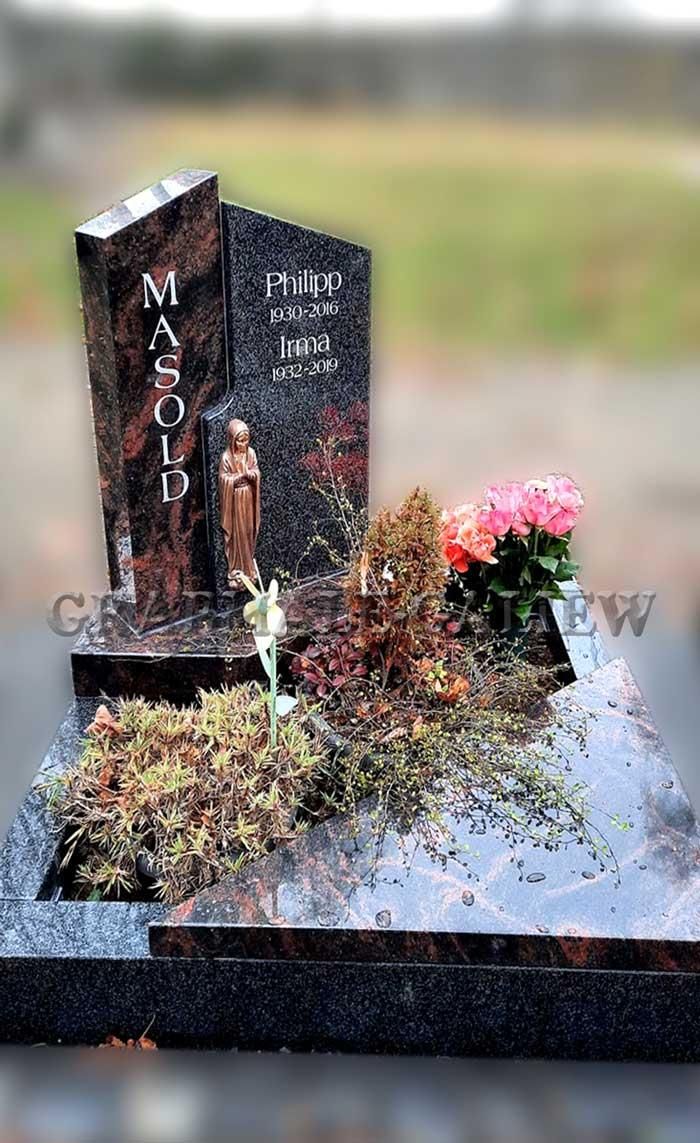 Ein Grab mit Blumen und einer Statue darauf