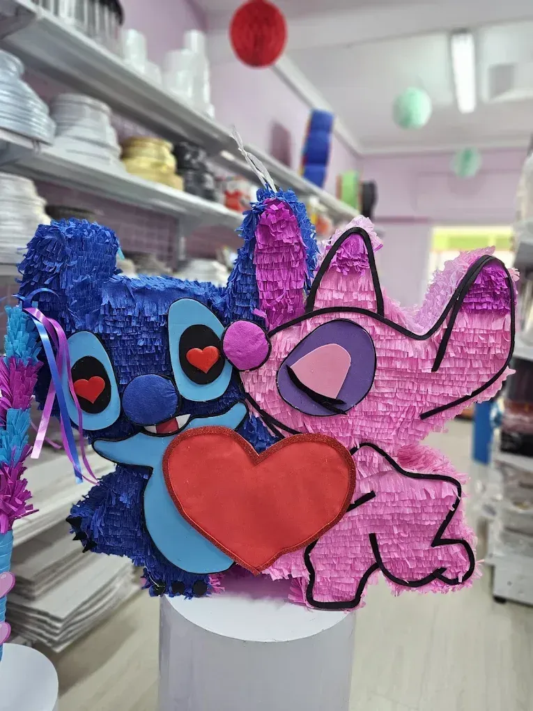 Piñata de Stitch y Angel abrazándose, sosteniendo un corazón rojo. Rosa y azul.