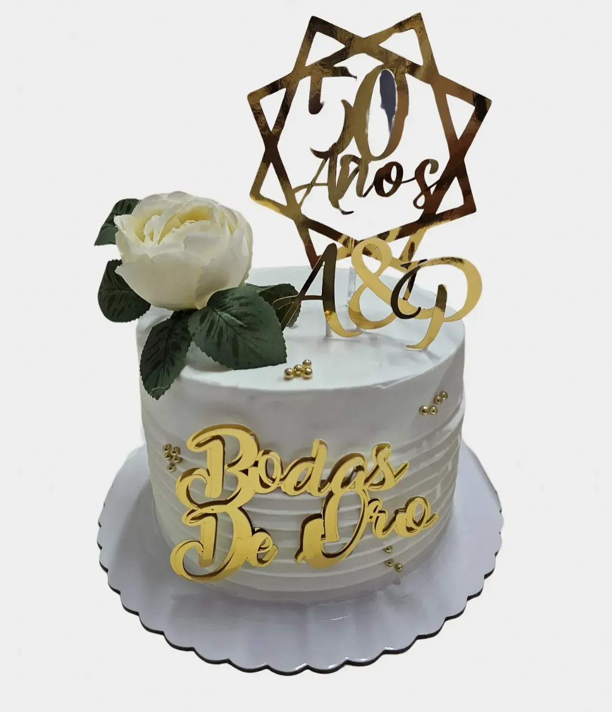 Pastel blanco decorado con detalles dorados, adorno que dice