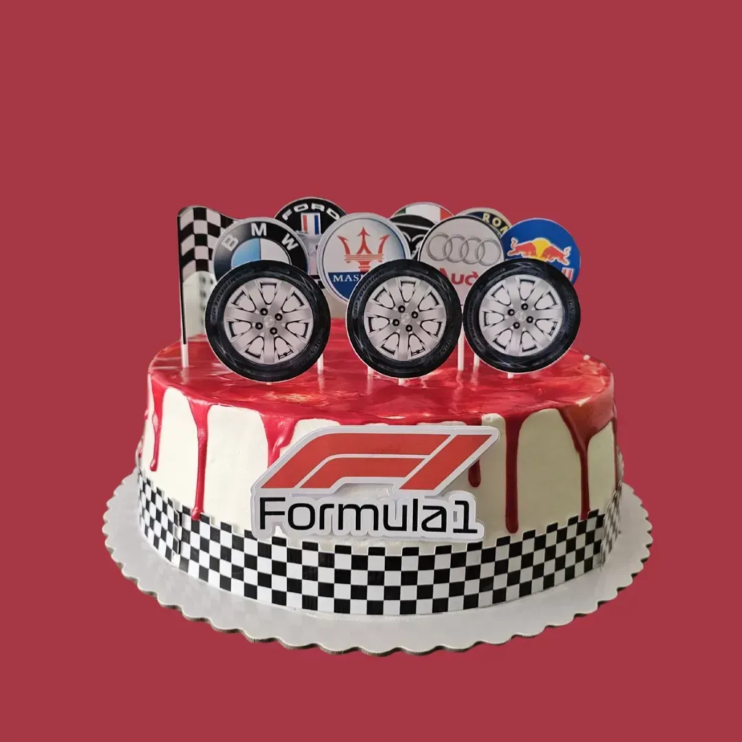 Tarta decorada con adornos de Fórmula 1 y ruedas de coche, glaseado rojo y borde a cuadros.