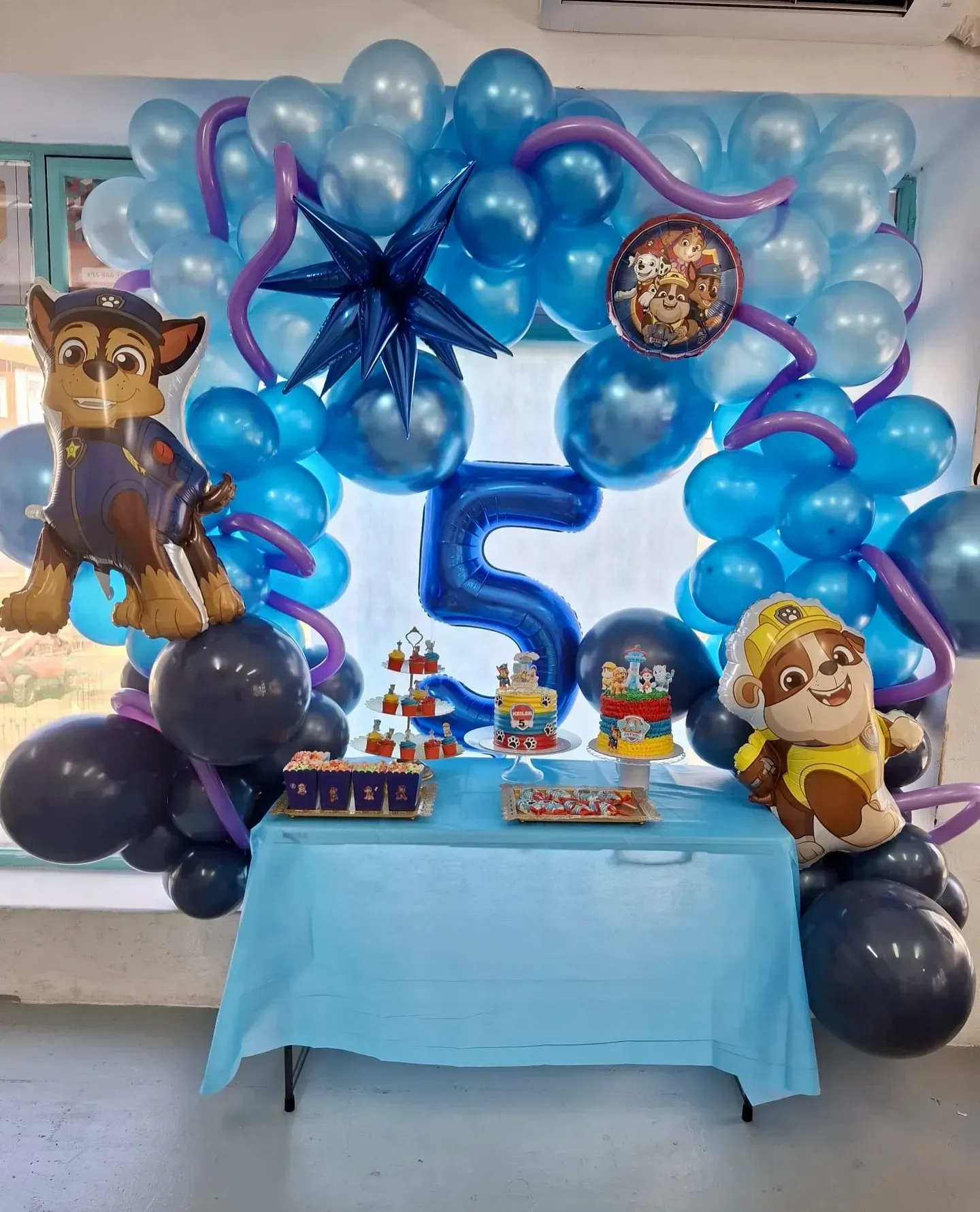 Decoración de fiesta temática de Paw Patrol con globos, mesa, personajes y un