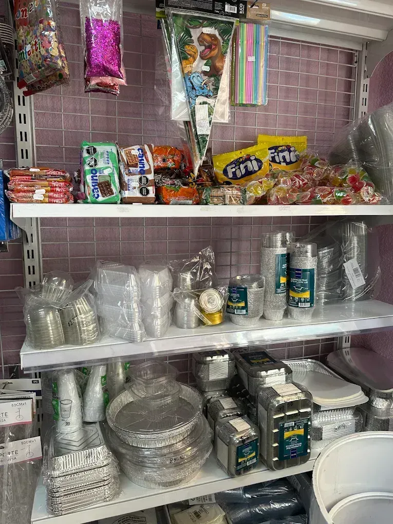 Estanterías repletas de diversos artículos para fiestas, incluyendo aperitivos,