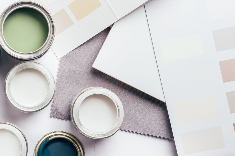 Nuanciers et échantillons de peinture dans des tons doux de vert, blanc, gris et bleu.