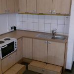 eine Küche mit Holzschränken, Spüle, Herd und Mikrowelle. kindergartenküche, Schreinerei Molitor