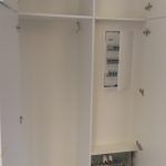 ein weißer Schrank mit einem Spiegel an der Wand. Schreinerei Molitor