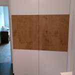 ein weißer Schrank mit Holztüren in einem Flur. Schreinerei Molitor